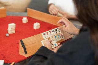 Tuiles numérotées alignées sur un chevalet et cartes à jouer posées à côté